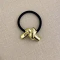 Minimalist elastic hair tie featuring a polished gold-tone geometric metal knot detail - Knot Bow Smooth Gold