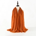 Burnt orange crinkle cotton linen scarf with frayed edges displayed on a mannequin - Burnt Orange