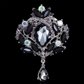 Macro detail of vintage alloy brooch with grey pear-shaped gem and multicolored rhinestones - Black