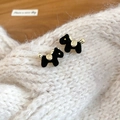 Vista macro de pendientes de caballo bañados en oro 18k con acabado negro sobre punto - Forma de Perro Negro