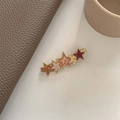 Détail de la pince à cheveux dorée à cinq étoiles avec étoiles colorées en acétate - Étoile Rouge Vin Rose