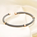 Detail view of woven stainless steel cable bracelet in charcoal grey and rose gold finish - Rose Gold & Steel