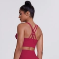 Detail of burgundy cross-back sports bra with multi-strap design for fitness training - Carmine