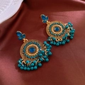 Close-up of vintage gold earrings with blue rhinestones and dangling bead tassels - Steel Needle - Blue