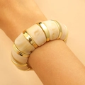 Detail eines breiten Harzarmreifs mit beigem Marmormuster und goldenem Metallband am Handgelenk - Breiter Elastischer Stil (KC Gold-33)
