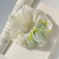 Creamy ballet style oversized scrunchie with pastel yellow fabric on an open book - White Green Plaid