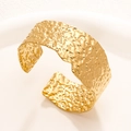 Modern 18K gold plated wide cuff bracelet with textured hammered finish on white tray - Gold