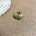 Nahaufnahme eines grünen Harzrings mit Marmorierung auf minimalistischem Hintergrund - Grüner Marmor