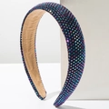 Close-up of rainbow rhinestones and soft brown velvet lining on a sponge headband - Deep purple