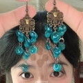 Close-up of vintage bronze dangling earrings with blue beads and hollow metal design - 1# Earring Hook-Lake Blue-Round
