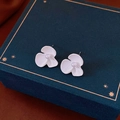 Macro detail of white enamel flower earrings with pearl centers on a blue velvet jewelry box - 12# White 3-Petal Flower