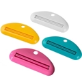 Spremi-dentifricio manuale in plastica in quattro colori vivaci su sfondo bianco puro - Avorio