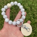 Nordic style volleyball beaded bracelet keychain with wooden tag on grass background - White & Black Volleyball Style