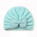 Close-up of mint green knitted baby hat featuring a large soft decorative bow detail - Mint Green