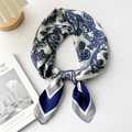 Elegant silk scarf featuring blue paisley patterns tied in a bow on a white surface - Navy Blue Paisley