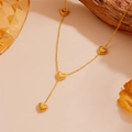 Close-up of golden stainless steel necklace with textured heart pendants on a warm background - Heart Pendant Tassel Necklace (I404)