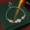 Macro detail of silver gourd pendant bracelet with zircon on green jewelry box - Silver