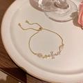 Elegant adjustable gold flower bracelet with sparkling zircons on a ceramic tray - S755 Gold