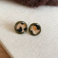 Close-up of leopard print resin hoop earrings with army green trim on beige fabric - Round / Army Green Leopard