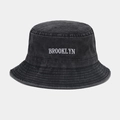 Detailed view of white Brooklyn embroidery on dark gray washed denim bucket hat - M (56-58cm) / Black