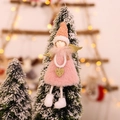 Angelo di Natale in peluche rosa con ali di paillettes appeso a un albero innevato - Angelo con Gambe a Penzoni Rosa