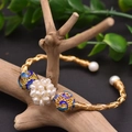 Golden twisted freshwater pearl bracelet with blue enamel beads on a rustic wood branch - Gold Pearl Ball Cloisonne Style