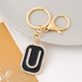 Macro detail of letter U keychain with black enamel and sparkling rhinestones - Letter U