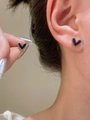 Pendientes de corazón negro con borde de cuentas plateadas usados por una modelo femenina - Estilo Corazón - Color Acero (H-90)