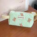 Close-up of quilted light green fabric with bear pattern and a branded fabric label - Wristlet / Mint Green Bear