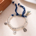 Macro detail of hand-woven bracelet with silver pendants and traditional lucky charms - L312 Fortune Cat (Blue Rope)