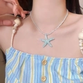 Primer plano de un collar con colgante de estrella de mar azul claro y cuentas blancas - 1# Collar de Estrella de Mar Azul