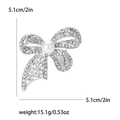 Silver bow brooch with rhinestones and central pearl, size 5.1cm and weight 15.1g - Silver
