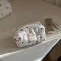 Detailansicht einer weiß gesteppten Baumwoll-Kosmetiktasche mit süßen Bärenmustern - Gestreifter Bär