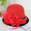 Detailed view of red wool felt hat with mesh veil, floral decor and feather accents - Ruby Red