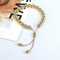 Vista dettagliata del bracciale con sfere dorate lucide e chiusura a scorrimento regolabile - Diametro perla 8mm / Oro
