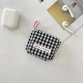 Detalle de una funda de tela para auriculares a cuadros blancos y negros con asa rosa. - Cuadros Negros Pequeños