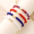 Close-up of four red white and blue Heishi bead bracelets with golden star charms - Five-pointed Star Style (1514)
