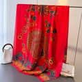 Dettaglio di uno scialle in raso rosso con piume di pavone e motivi floreali paisley - Rosso Arancio