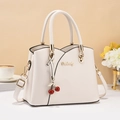 Elegante beige Damen-Handtasche aus Leder mit Kirsch-Anhänger und Schultergurt - Weiß