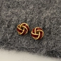 Macro view of French vintage knot stud earrings with red enamel and golden rope texture - Red Concentric Knot - Gold Plated