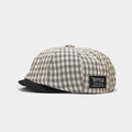 Dettaglio del berretto newsboy a scacchi con toppa alla moda e visiera nera solida - Taglia unica / Beige