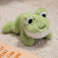 Cute green plush frog magnet toy with fluffy texture and round body in a lying position - Frog
