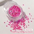 Macro detail of mixed size aurora mermaid bubble glass beads in vibrant pink for nail art - Mocha Magenta