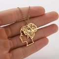 Gold stainless steel necklace with stylized cartoon girl pendant held in hand on white background - Golden Bun Girl