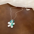 Detail of silver flower necklace with light blue gemstone pendant on brown surface - Flower Cat's Eye Pendant Necklace (Silver/Blue)