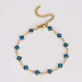 Dettaglio bracciale a catena dorata con pendenti quadrati glitterati blu e chiusura - Celeste