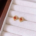 Détail macro de boucles d'oreilles vintage dorées avec gemmes rouges en boîte - Style de fleur creuse en zircon rond rouge / Or-Rouge