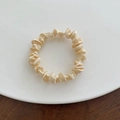 Primer plano de un coletero de satén beige plisado sobre un plato de cerámica blanca - Pequeño / Blanco Roto