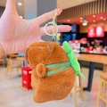 Plush Capybara keychain with a small green backpack and gold ring attachment - Turtle Shell Dress-Up Capybara