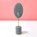 Silver metal necklace with pink crystal flower pendant on gray velvet display stand - Gray